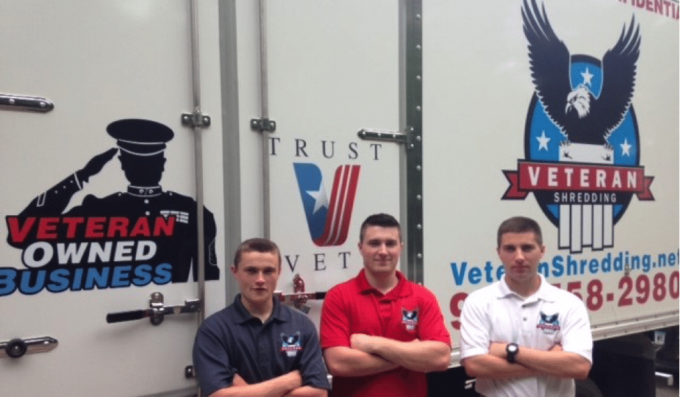 Three employees posing for picture next to Shred truck